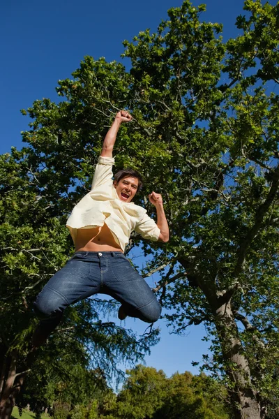 L'uomo che alza braccia e gambe mentre salta in festa — Foto Stock