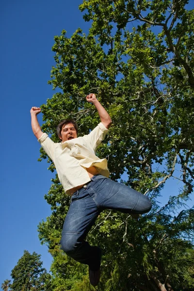 Człowiek podnoszenie obu rękami i obie nogi, jak skacze w — Zdjęcie stockowe