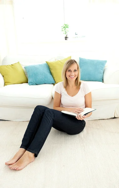 Carina donna che legge un libro in soggiorno Foto Stock
