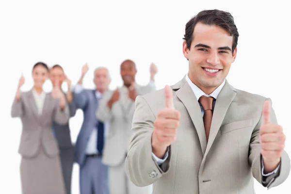 Salesman with team behind him giving thumbs up — Stock Photo, Image