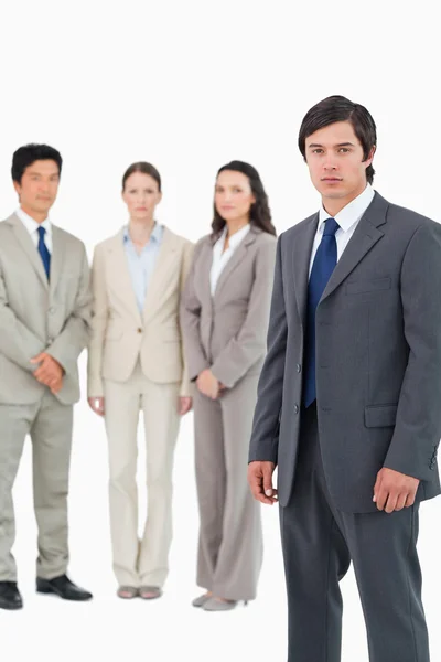 Serious young businessman with team behind him — Stock Photo, Image