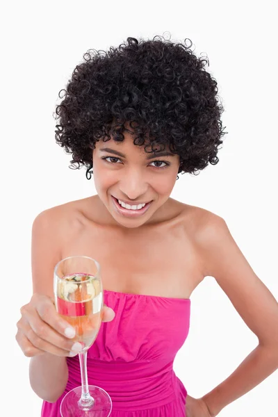 Young woman showing a beaming smile while holding a glass of cha Stock Photo