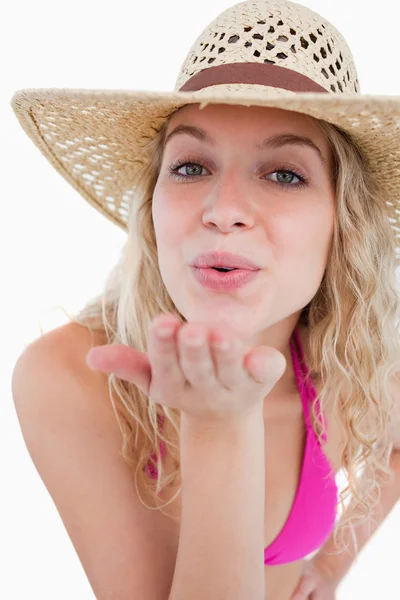 Young blonde woman sending an air kiss in front of the camera Stock Photo