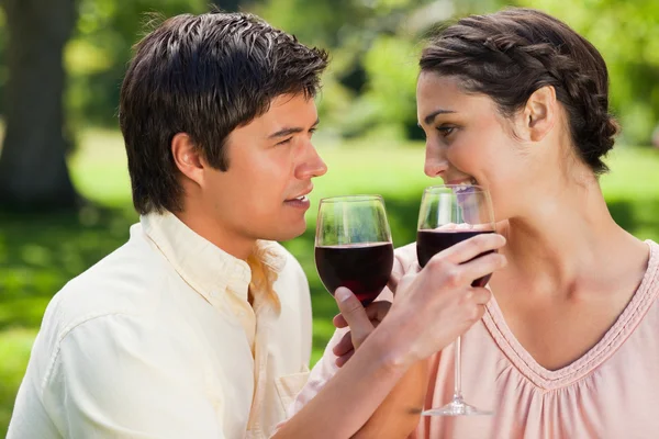 Two friends linking their arms while holding glasses of wine — Stock Photo, Image