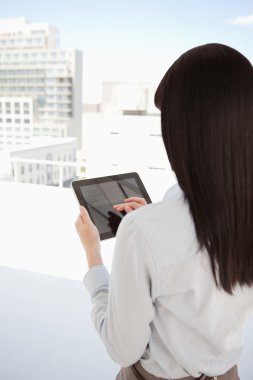 A woman in her office using her tablet pc clipart