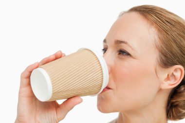 Close-up of a woman in a suit drinking a takeaway coffee clipart