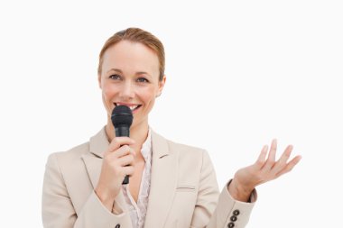 Pretty woman in a suit speaking with a microphone clipart