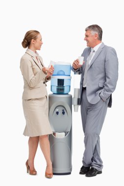 Business talking next to the water dispenser clipart