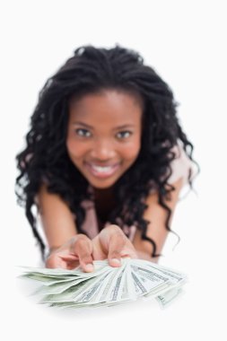 A smiling woman is holding American dollars out in front of her clipart