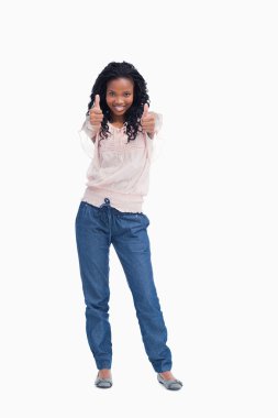 A young woman standing with her thumbs up clipart