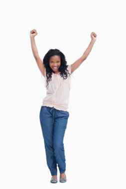 A young happy woman stands with her hands in the air clipart