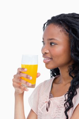 A side shot of a girl holding a glass of orange juice clipart