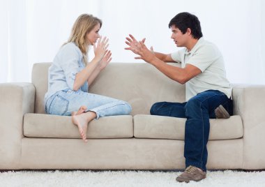 A couple sitting on a couch are having an argument clipart