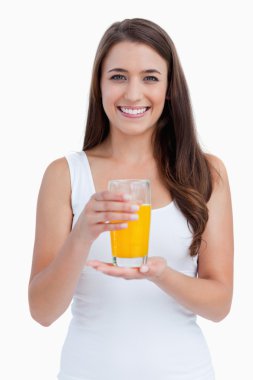 Smiling woman holding a glass of orange juice clipart