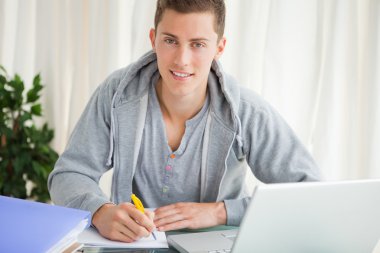 Portrait of a student doing his homework clipart