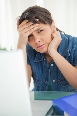 Portrait of a female student having a headache clipart