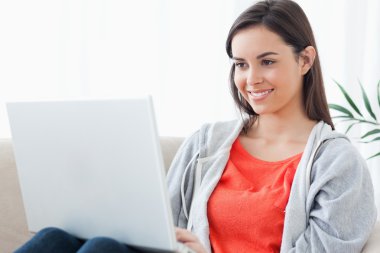 A woman with a lovely smilw using her laptop clipart