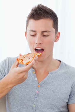 Close up of a man as he is about to eat the slice of pizza he is clipart