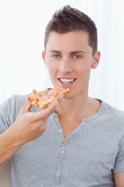 A smiling man holding pizza as he is about to eat clipart