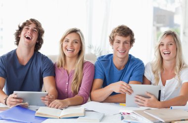 Two couples sit together and work with the help of tablet pc's clipart