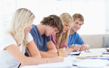 A group of students working as one student looks at the camera w clipart