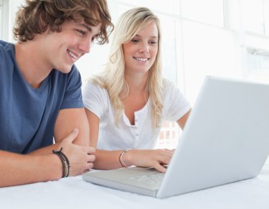 A group of smiling friends looking at the laptop clipart