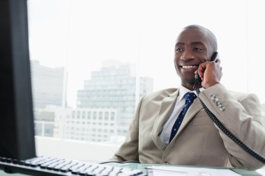 Smiling businessman on the phone clipart