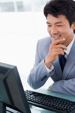 Portrait of a smiling manager using a computer clipart