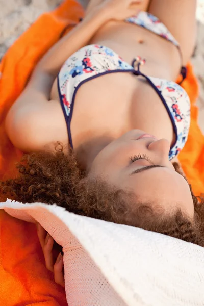 Mladá uvolněná žena podřimuje na její plážový ručník — Stock fotografie