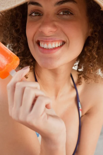 Mujer joven mostrando una gran sonrisa mientras sostiene una paleta — Foto de Stock