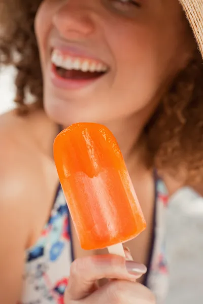 stock image Orange popsicle held by a smiling young woman