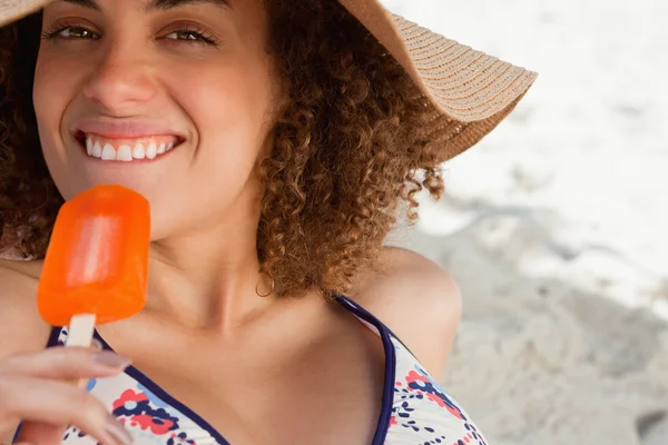 Young attractive woman going to eat an orange ice lolly on the b — Stock Photo, Image