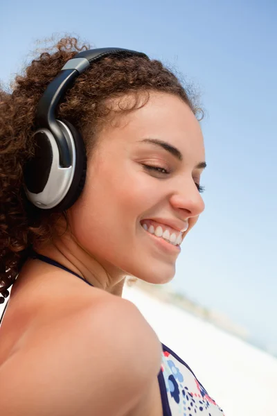Mujer atractiva joven con un auricular mirando hacia el lado — Foto de Stock