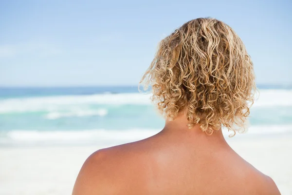 Bakifrån av en blond man stående på stranden — Stockfoto