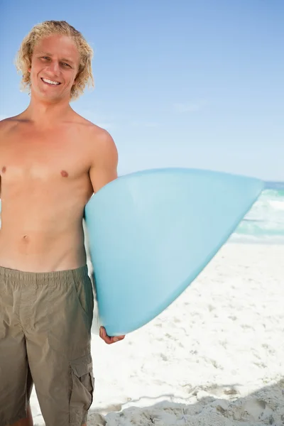 Genç gülümseyen adam mavi onun surfboard holding — Stok fotoğraf