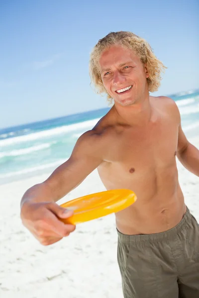 Usměvavá blondýnka muž stojí při hraní s žlutou frisb — Stock fotografie