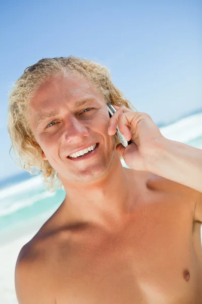 Усміхнений блондинка дивиться на камеру під час дзвінка зі своїм — стокове фото