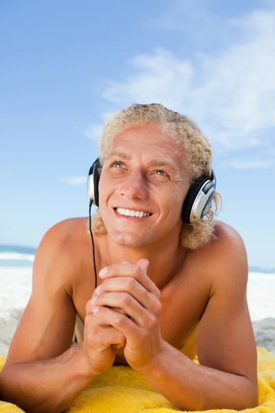 Smiling man looking up while listening to music with his headset — Stock Photo, Image