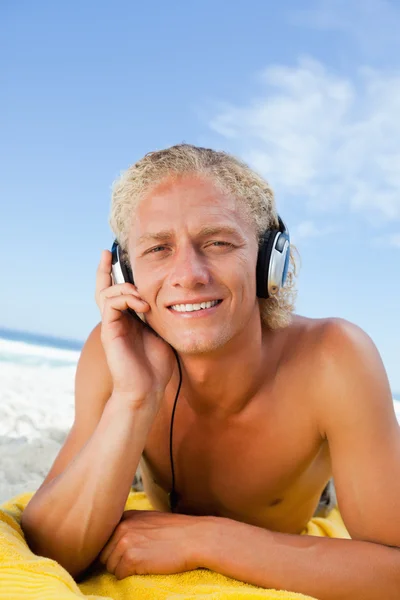 Fiatal szőke férfi figyelmesen hallgat zenét a fejhallgatóval — Stock Fotó