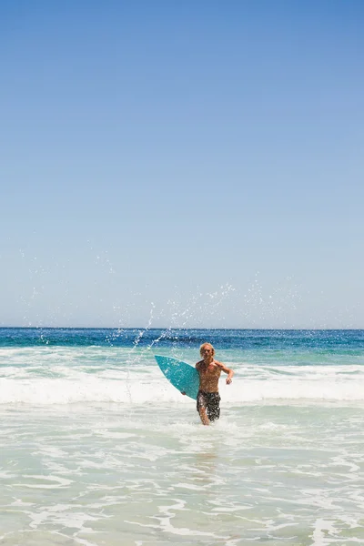 Jovem loira retornando à praia enquanto corre — Fotografia de Stock