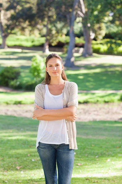 Kvinna med hennes armar vikta stående i parken — Stockfoto