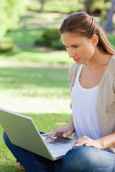 Woman sitting on the lawn with her notebook — Stock Photo, Image