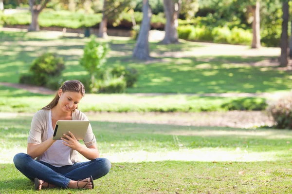 Frau mit Tablet-Computer im Park — Stockfoto