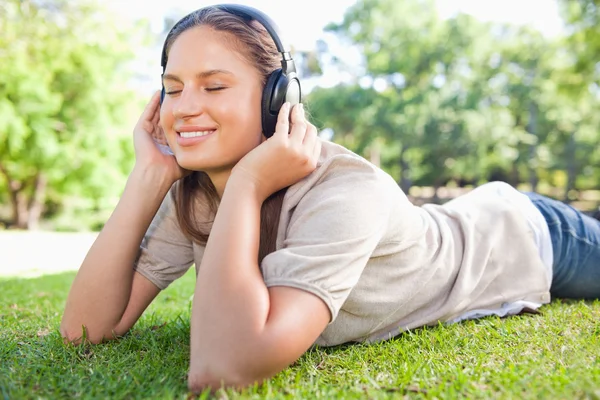 Žena užívat hudbu na trávníku — Stock fotografie