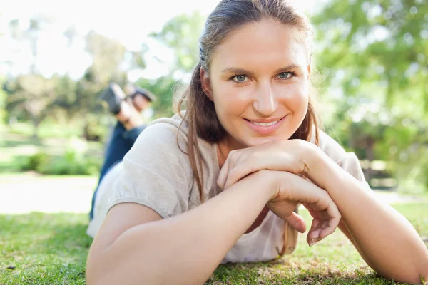 Mujer sonriente acostada en la hierba — Foto de Stock