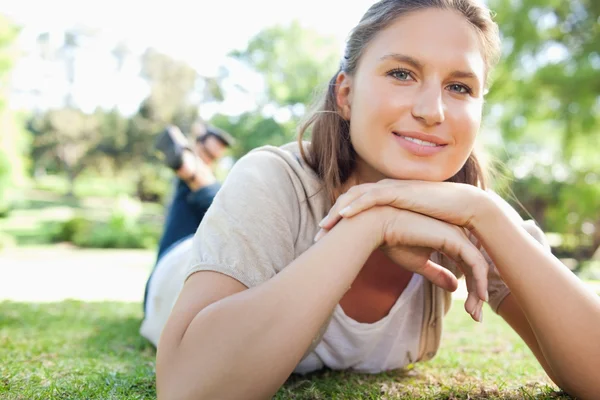 Femme souriante allongée sur la pelouse — Photo