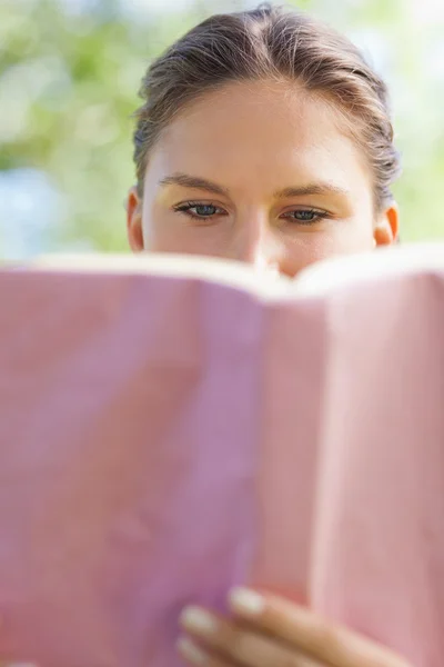 Een vrouw die een boek leest in het park — Stockfoto