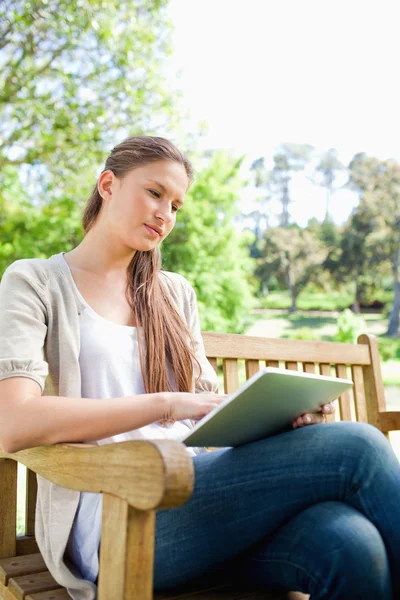 Femme avec un ordinateur tablette assis sur un banc — Photo
