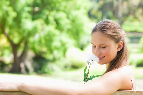 Widok z boku kobiety, pachnący kwiat — Zdjęcie stockowe