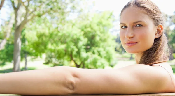 Bir bankta oturan bir kadın yan görünüm — Stok fotoğraf